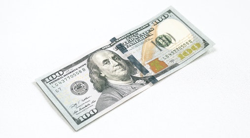 100 dollar bill on white surface